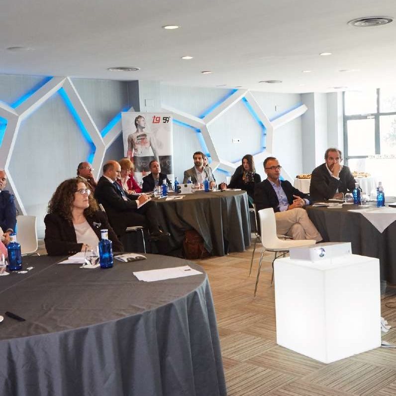 Comité reunido en mesa redonda con equipo audiovisual