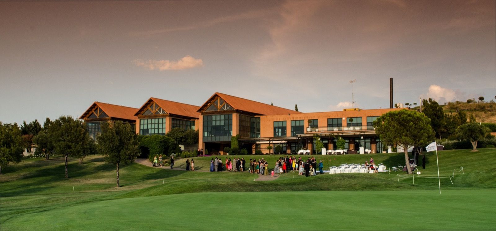El club visto desde el campo, con invitados en el césped