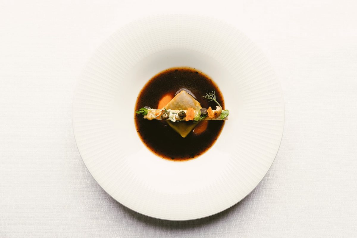 Caldo servido sobre un raviolo