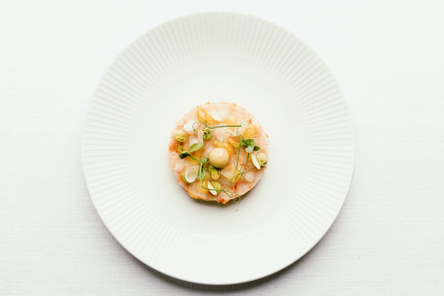 Tartar con brotes y encurtidos, emplatado en la cocina del club